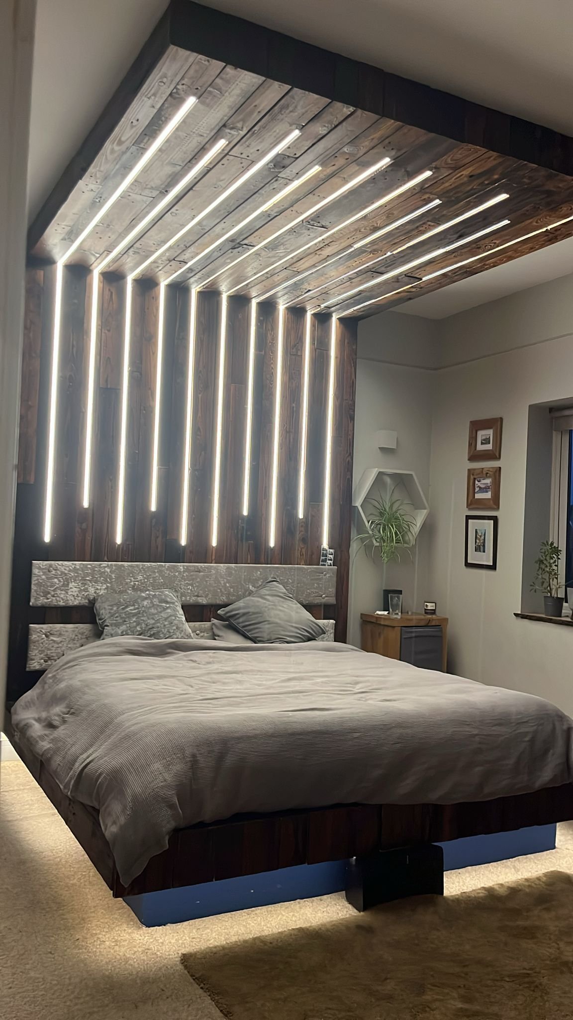Bali-style canopy bed with radiating LED strips across a reclaimed-wood ceiling