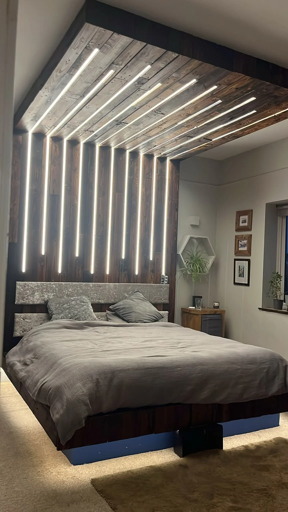 Bali-style canopy bed with radiating LED strips across a reclaimed-wood ceiling