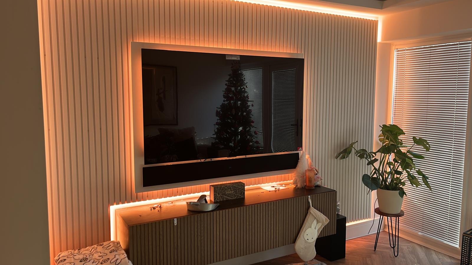 Vertical oak slat panelling around a wall-mounted TV