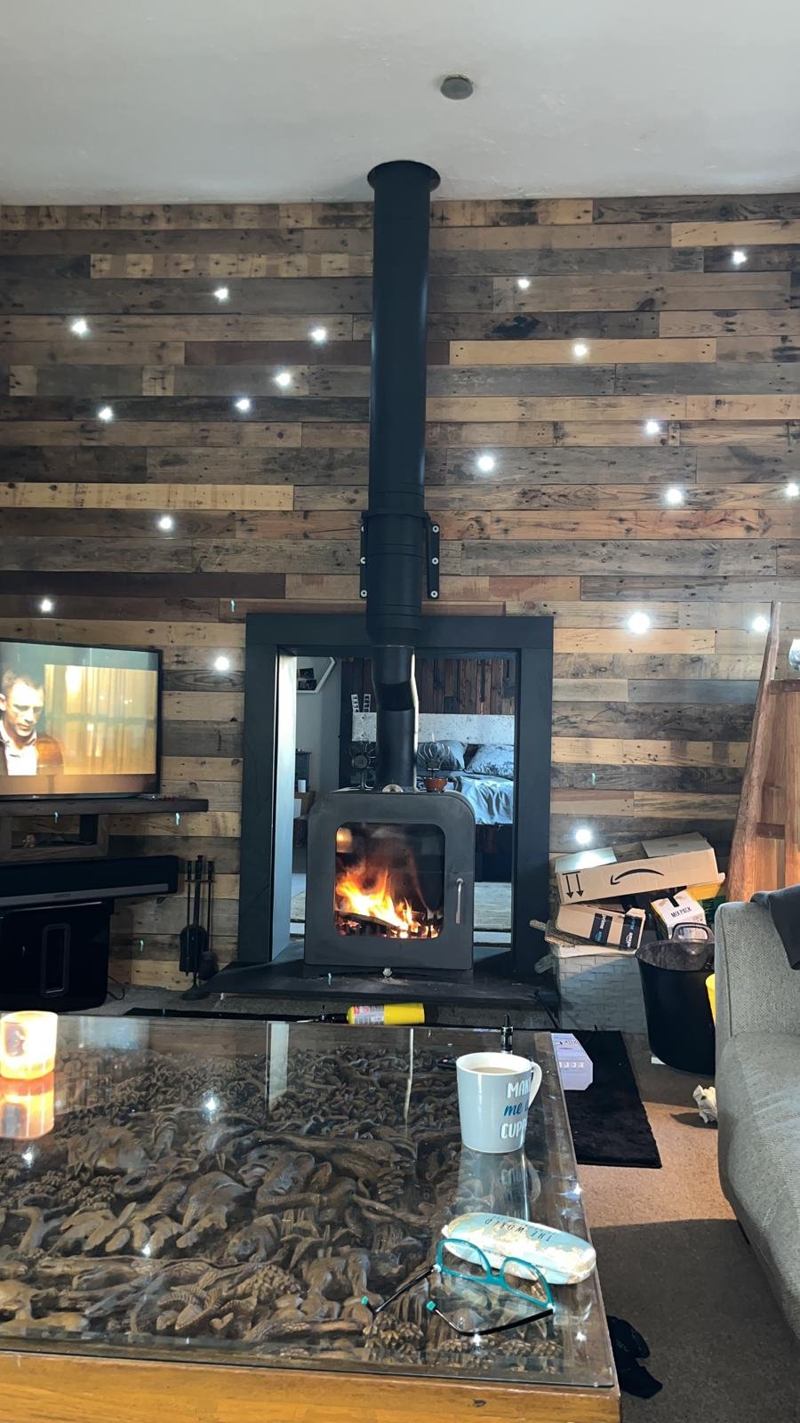 Reclaimed wood media wall with an integrated woodburner